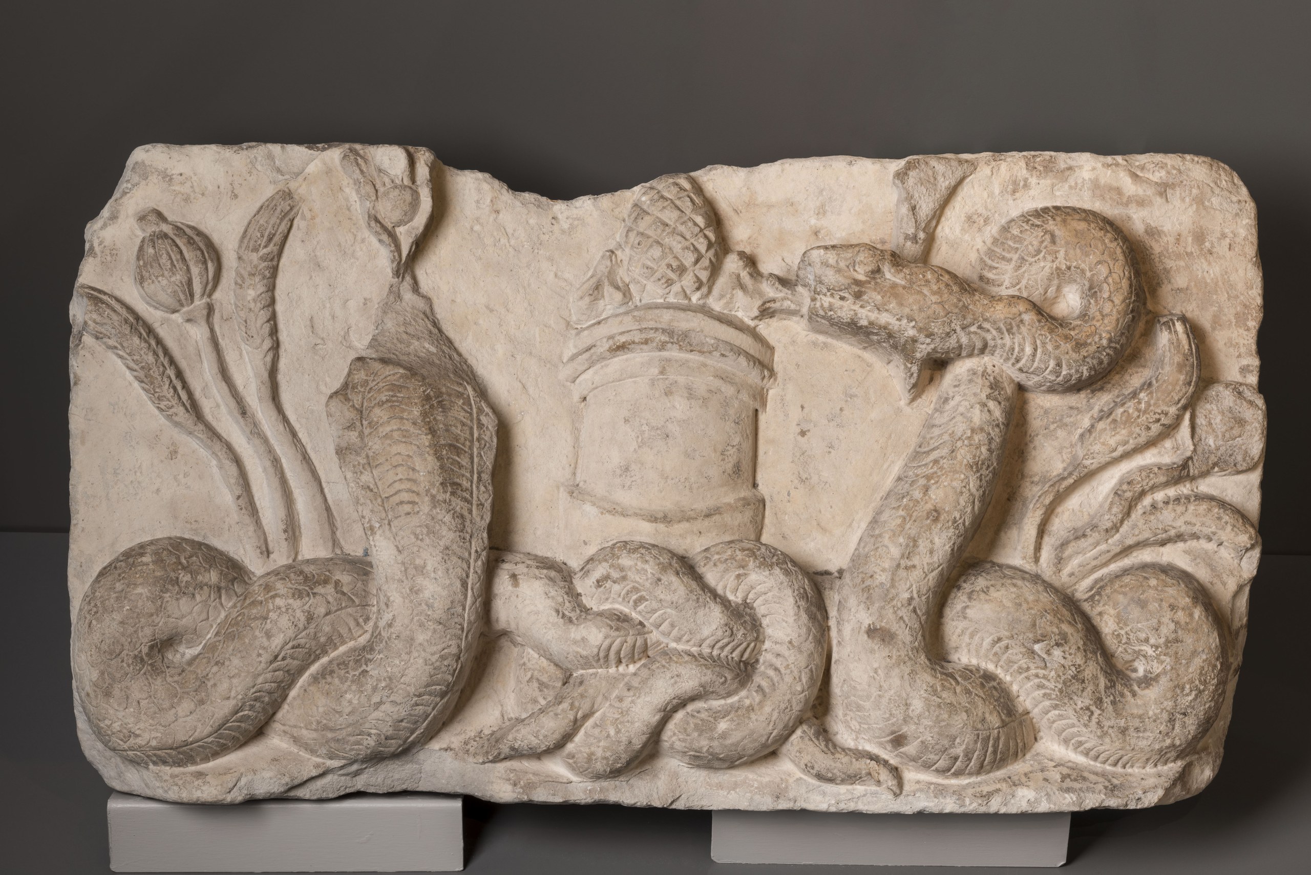 High relief of Isis with bovine crown and Termuthis, both depicted as snakes