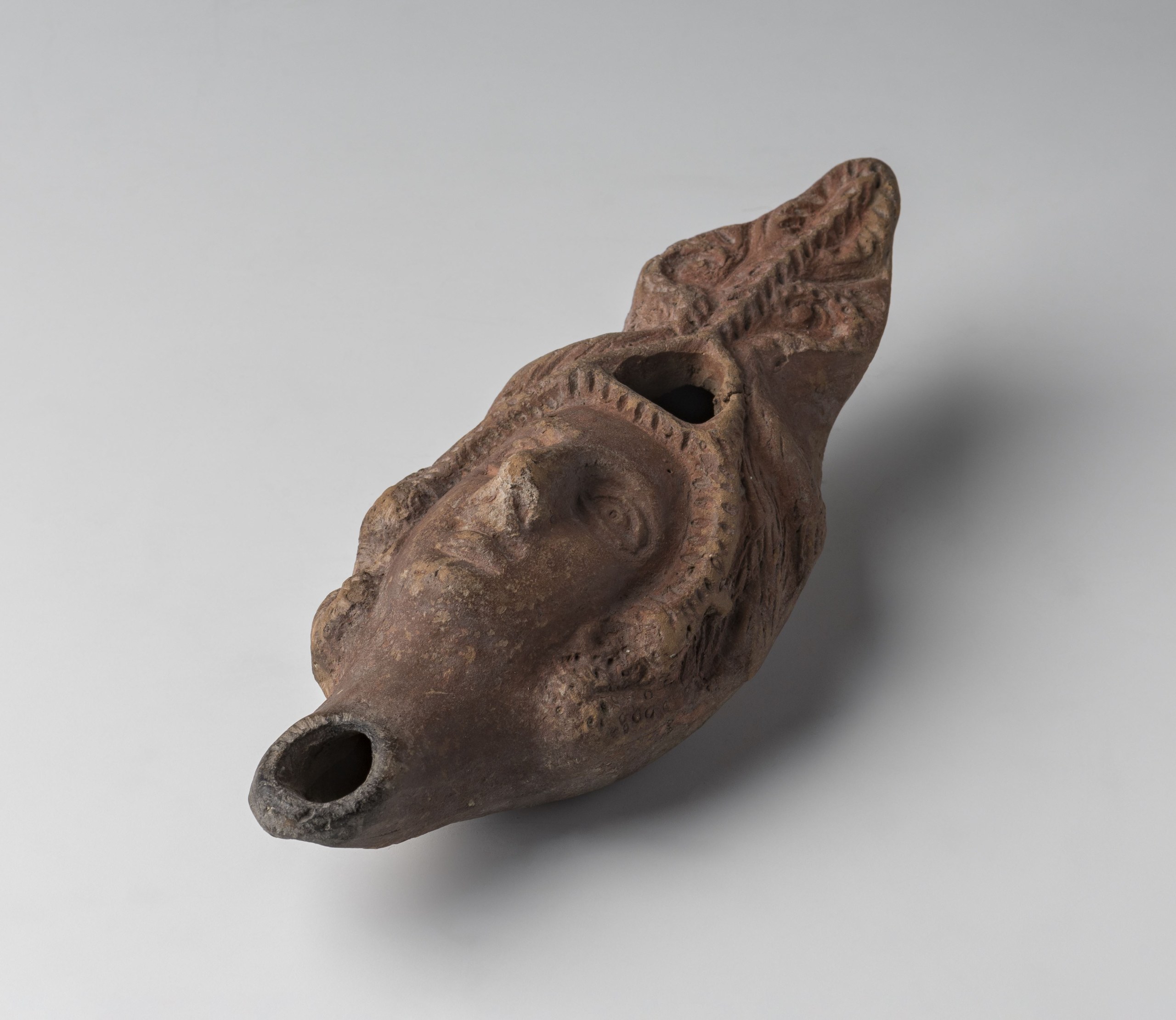 Lamp with palmette handle, shaped as a female head