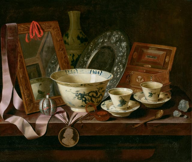 Chinese porcelain cups and a bowl, with a mirror, a silver platter and a portrait medal, with other objects on a table
